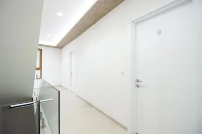 a hallway with white walls and a glass door at APART-HOTEL PRESiDENT 2 in Ulcinj