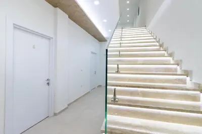 a staircase in a building with white walls and white floors at APART-HOTEL PRESiDENT 2 in Ulcinj