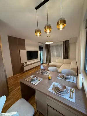 a kitchen and living room with a table and chairs at Diamond H in Podgorica