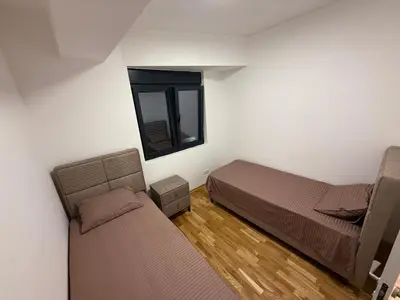 a room with two beds and a mirror in it at Diamond H in Podgorica