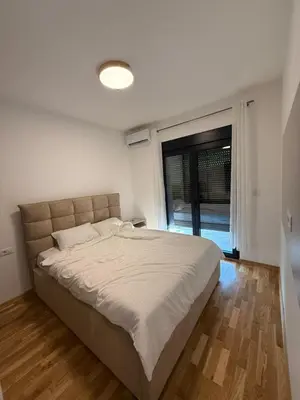 a bedroom with a large bed with a large window at Diamond H in Podgorica
