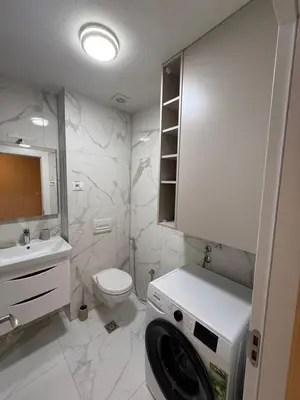 a white bathroom with a sink and a toilet at Diamond H in Podgorica