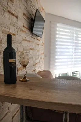 a bottle of wine and a wine glass on a table at Budva Apartmani in Budva