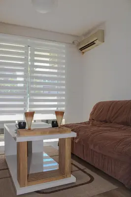 a living room with a coffee table and a bed at Budva Apartmani in Budva