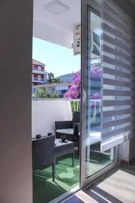 a sliding glass door leading to a patio with a table at Budva Apartmani in Budva