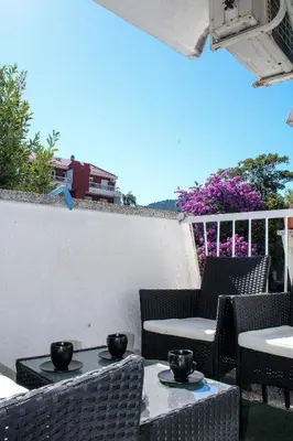a patio with two tables and chairs on a balcony at Budva Apartmani in Budva