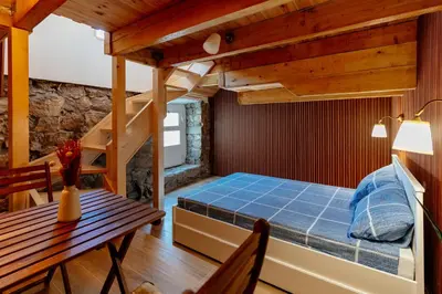 a bedroom with a bed and a staircase and a table at Pelican Bay House - Skadar Lake in Krnjice