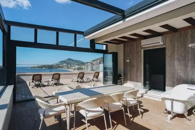 a dining room with a table and chairs on a patio at Penthouse with Sea view Rafailovici in Budva