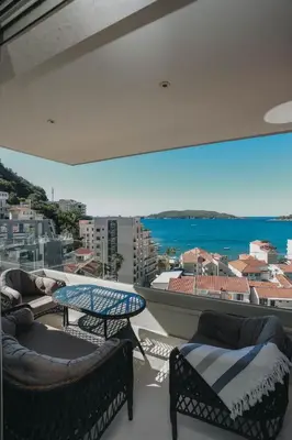 a balcony with chairs and a table and a view of the ocean at Penthouse with Sea view Rafailovici in Budva