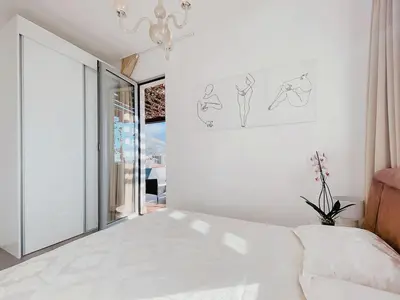 a white bedroom with a bed and a window at Luxury Horizon Penthouse Budva in Becici