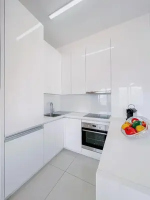 a white kitchen with a bowl of fruit on the counter at Luxury Horizon Penthouse Budva in Becici