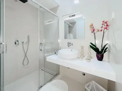 a white bathroom with a sink and a shower at Luxury Horizon Penthouse Budva in Becici