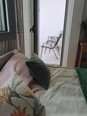 a bed in a room with a view of a patio at Ardea apart in Budva
