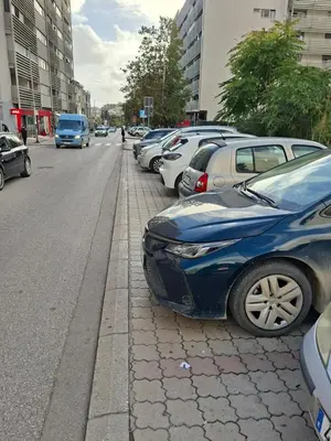 a bunch of cars parked on the side of a street at Ardea apart in Budva