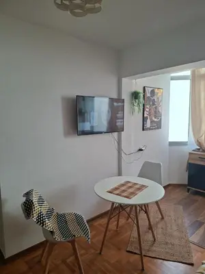 a living room with a table and two chairs and a tv at Ardea apart in Budva