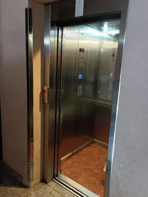 an elevator with a glass door in a building at Ardea apart in Budva
