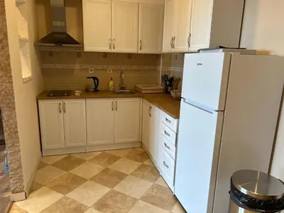 a kitchen with white cabinets and a white refrigerator at Apartman u Bečićima in Budva
