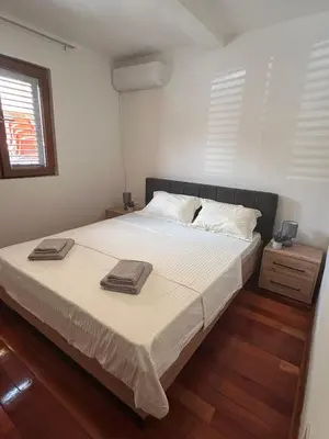 a bedroom with a large bed with two towels on it at Apartman u Bečićima in Budva