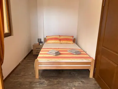 a small bedroom with a bed in a room at Apartman u Bečićima in Budva