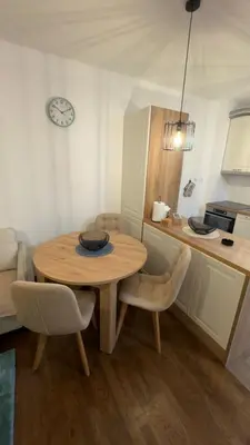 a kitchen with a table and chairs and a kitchen with a microwave at Galeb Family Apartments in Budva