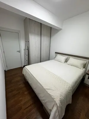 a bedroom with a large bed with white sheets at Galeb Family Apartments in Budva