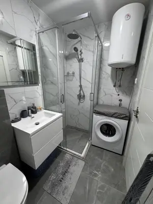 a bathroom with a shower and a washing machine at Galeb Family Apartments in Budva