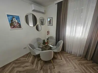 a dining room with a glass table and chairs at Stay Point Jerry - Podgorica City Apartment in Podgorica