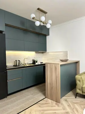 a kitchen with blue cabinets and a counter top at Stay Point Jerry - Podgorica City Apartment in Podgorica