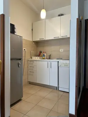 a kitchen with white cabinets and a stainless steel refrigerator at Stex Elite City Kvart in Podgorica