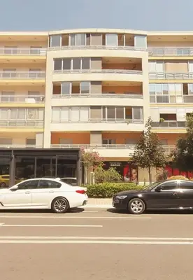 two cars parked in front of a large building at Stex Elite City Kvart in Podgorica