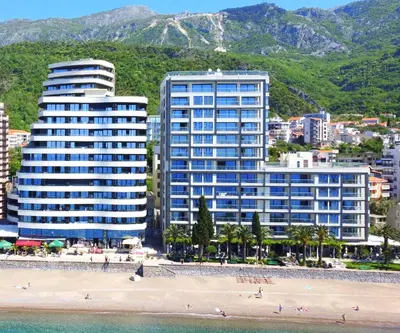 two tall buildings on a beach next to a beach at Azure Coast Residence Rafailovici -Seaside Living Apartments in Becici