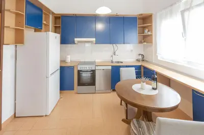 a kitchen with blue cabinets and a wooden table at Parkview Bar in Bar