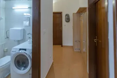 a bathroom with a washing machine and a toilet at Parkview Bar in Bar