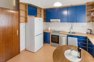 a kitchen with blue cabinets and a white refrigerator at Parkview Bar in Bar