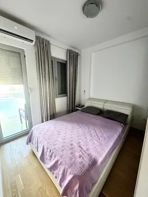 a bedroom with a bed with a purple comforter at Apartment Central Budva in Budva