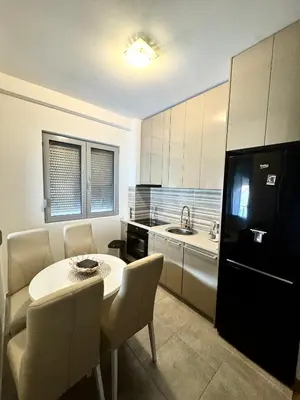 a small kitchen with a table and a black refrigerator at Apartment Central Budva in Budva