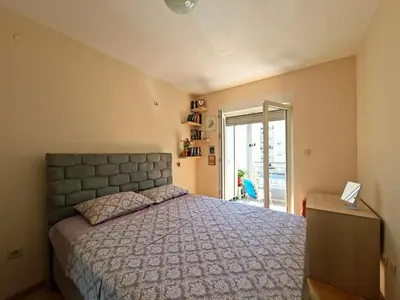 a bedroom with a bed and a door to a balcony at The Lilac Lounge in Podgorica