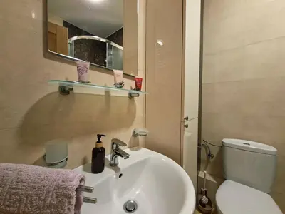 a bathroom with a sink and a toilet and a mirror at The Lilac Lounge in Podgorica
