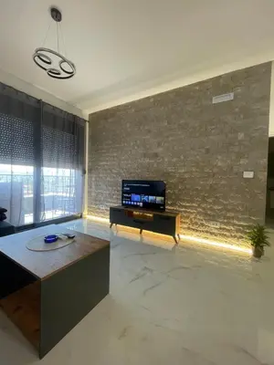a living room with a tv on a brick wall at Apartman Celuga in Bar