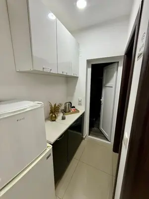 a kitchen with white cabinets and a white refrigerator at Guest house, Small beach in Ulcinj