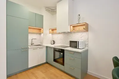 a kitchen with white cabinets and a microwave at Skyline resort CG in Budva