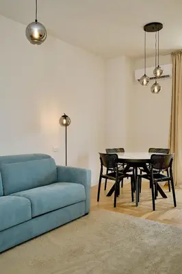 a living room with a blue couch and a table at Skyline resort CG in Budva