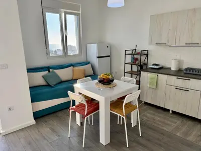 a small kitchen with a table and chairs in a room at Apartment LULU in Bar