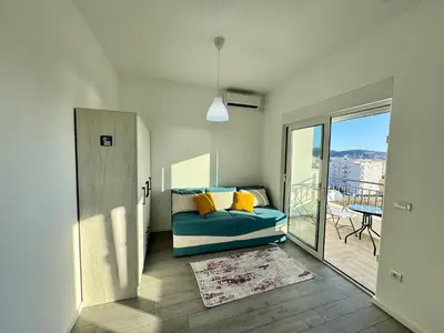 a living room with a blue couch and a balcony at Apartment LULU in Bar