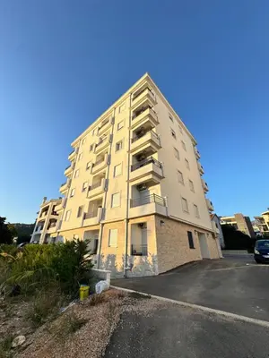 a tall building with a parking lot in front of it at Apartment LULU in Bar