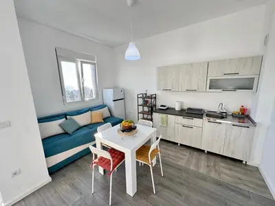 a kitchen and a living room with a couch and a table at Apartment LULU in Bar