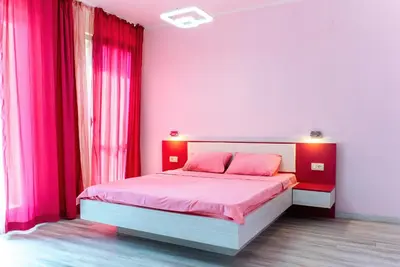 a bedroom with pink walls and a bed with pink sheets at Harmonia Sunrise Apartments in Budva