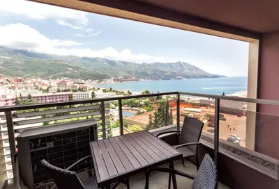 a balcony with a table and chairs and a view of the ocean at Harmonia Sunrise Apartments in Budva