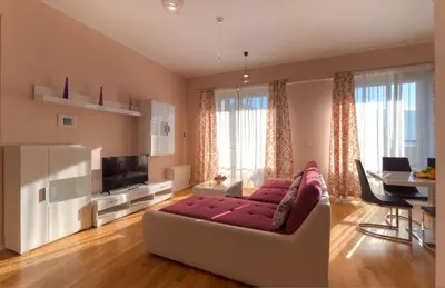 a living room with a couch and a television at Harmonia Sunrise Apartments in Budva