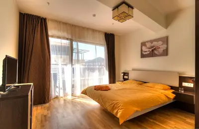 a bedroom with a bed and a large window at Harmonia Sunrise Apartments in Budva